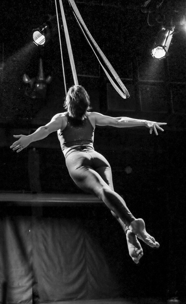 Aerial straps performer on stage, black and white