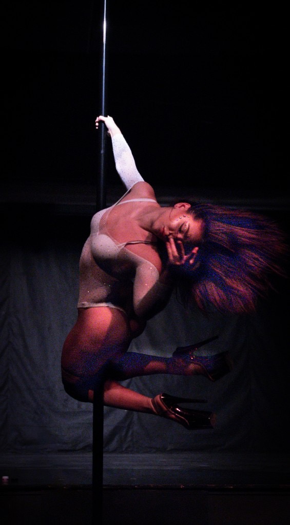 Pole dancer in sparkling bodysuit, dramatic lighting