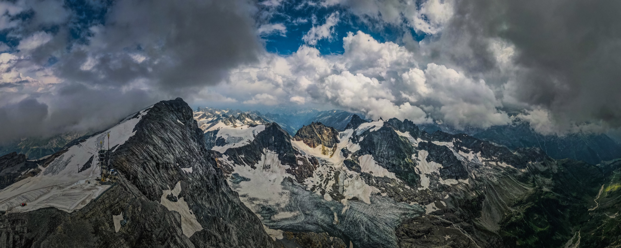 Snow-capped alpine peaks above clouds, aerial view