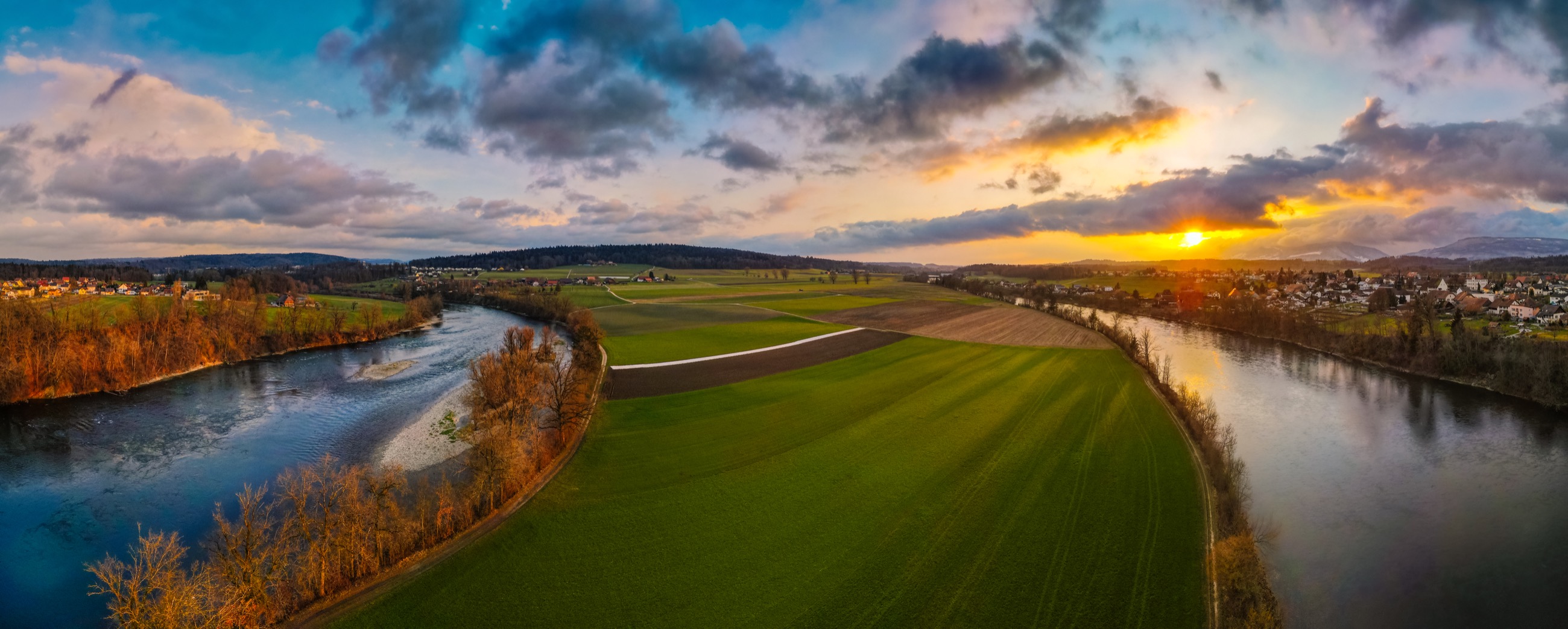 River valley and farmland at golden hour, aerial panorama